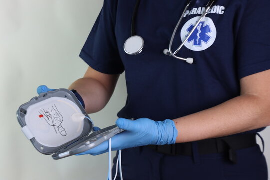 Paramedic holding a defibrillator pads in the hands to rescue in an emergency