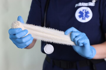 Woman paramedic professional holding a elastic crepe bandage roll in the hands