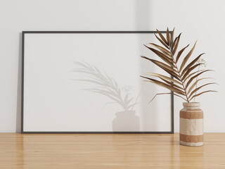 Horizontal frame mockup on a wooden table decorated with an ornamental plant. 3D rendering,...