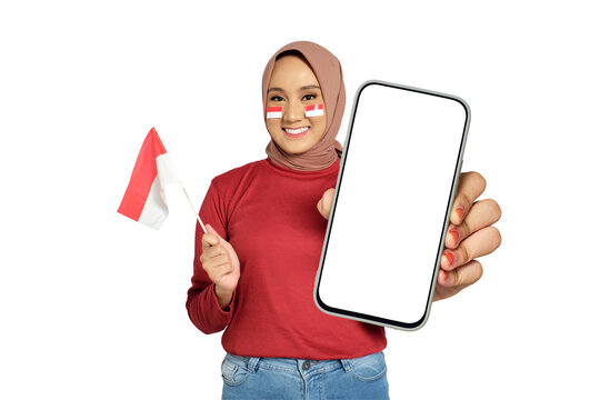 Excited young Asian women celebrate Indonesian independence day on 17 August while holding smartphone with blank screen and Indonesian flag isolated on transparent background - Powered by Adobe