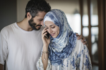 Mid Mid-adult Middle Eastern couple using phone at home