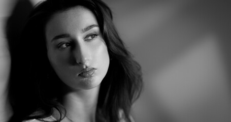 Black and white portrait of a sad young woman looking away