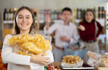 Mom and dad yell at daughter for choosing unhealthy food in store. Girl child has collected many...