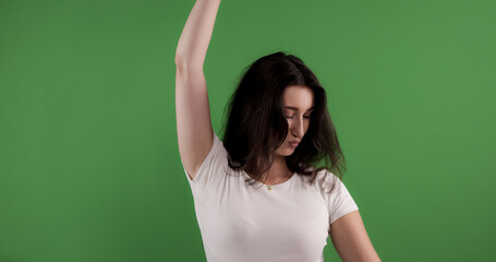 Young woman wearing white t shirt raising arm on chroma key green background