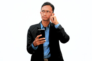 An Asian business man holding a cell phone with a thoughtful expression.