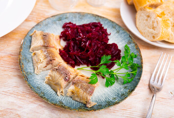 Appetizing baked mackerel, cut into pieces, with grated boiled beetroot. Decorated with a sprig of...
