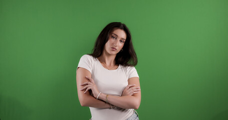 Young woman crossing arms showing confidence on green screen background