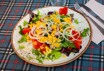 Light vegetable salad made from fresh chopped tomatoes, onions, lettuce leaves and corn
