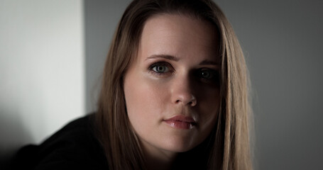 Studio portrait of a beautiful young woman with long brown hair and a serious expression