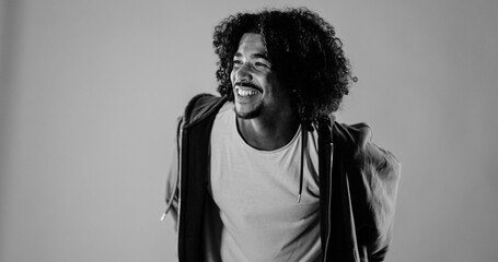 Studio portrait of a cheerful young african american man with curly hair looking away and smiling