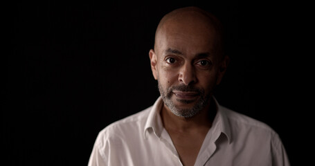 Studio portrait of a middle aged african american businessman wearing a white shirt on a black background