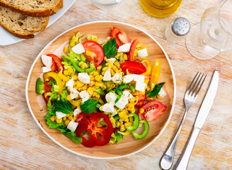 Delicious light vegetable salad of tomatoes, canned corn, pepper and Feta cheese