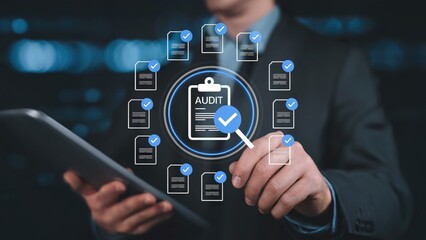 Businessman using a tablet with an audit concept showing compliance documents