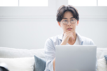  パソコンを見ながら考える男性困る悩むの表情