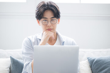  パソコンを見ながら考える男性困る悩むの表情