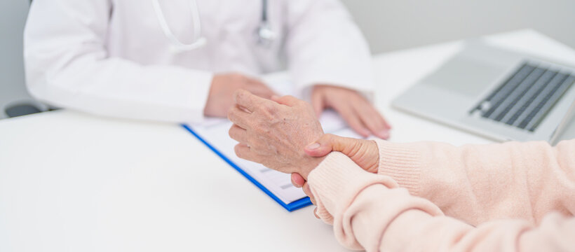 Elderly Patient Woman wrist pain and Consulting doctor. muscle ache from Carpal Tunnel Syndrome, De Quervain s tenosynovitis, rheumatoid, arthritis, gout, Parkinson disease and ergonomic healthcare - Powered by Adobe
