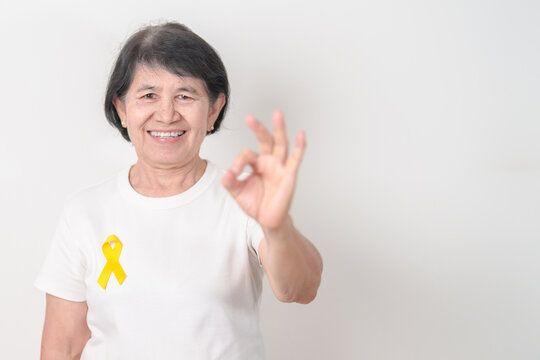 Elderly with Yellow Ribbon for concept of yellow September, Suicide prevention day, Childhood, July Sarcoma, support Our Troops and Military support. Healthcare and World Cancer day