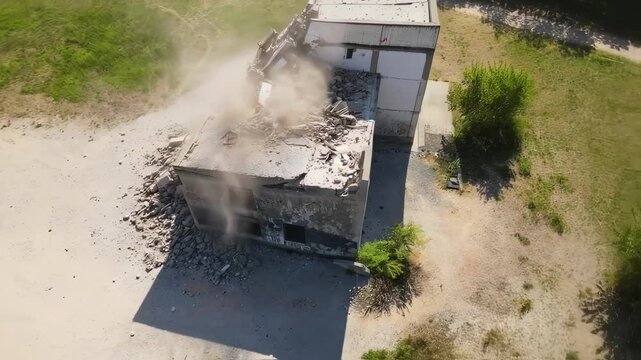 Controlled Implosion of a Building: Aerial View of Demolition Site with Dust and Debris
