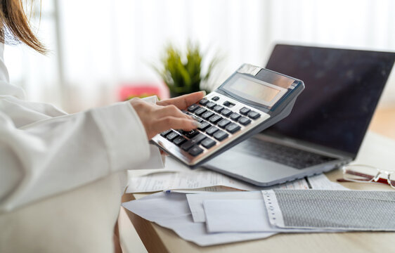 Human use calculator and calculate bills and paying bill, credit card, tax and vat, payment, concept of money management and business report with financial documents, financial accounting concept