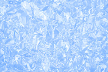 Obraz premium Wrinkled blue foil with sharp creases and glossy areas. The texture resembles frozen surfaces or icy patterns. It has a frosty, chilly look with a smooth metallic shine. 