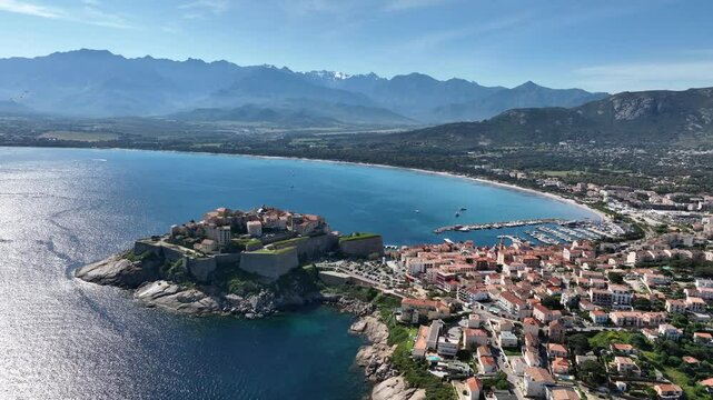 Calvi Citadel and Old Town Framed by Beach, Harbor, and Mountain Range