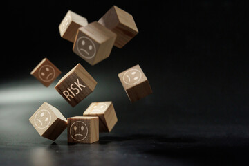 Falling Risk Blocks with Sad Faces Representing Business Uncertainty