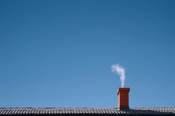 Red Brick Chimney with Smoke on Tiled Roof Against Clear Blue Sky, Heating Season, Home