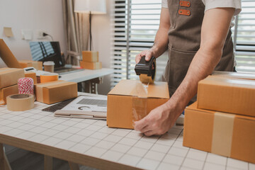 an employee is packing products into boxes to prepare for shipping to customers, a small online...