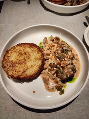 A delicious plate of beef stroganoff with a crispy potato pancake. Gourmet meal with a creamy...