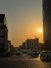 City street with heavy traffic during a beautiful golden hour sunset. Urban cityscape with cars on...