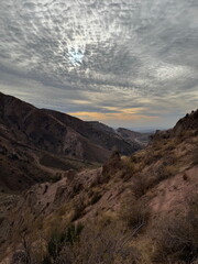 Dramatic Mackerel Sky Over a Mountain Valley. Scenic view of an arid canyon landscape at dusk with...