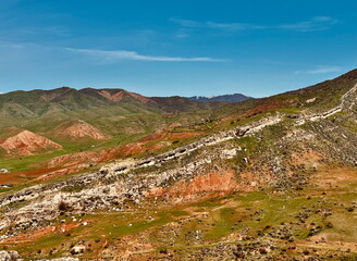 Vibrant mountain landscape with colorful red and green hills. Scenic view of a geological rock...