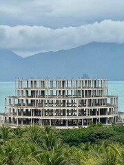 Abandoned circular concrete building under construction on a tropical coast. Derelict hotel project...