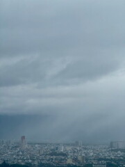 Gloomy cityscape under a dark stormy sky. Aerial view of a city on a rainy day with heavy clouds....