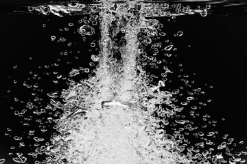 黒の背景に水中に舞い上がるたくさんの気泡.