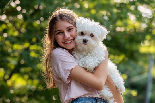 A woman holding a small white dog in her arms.