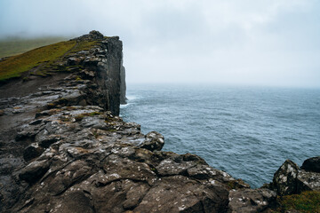 Sea cliffs of Traelanipa rise above the waves in the Faroe Islands