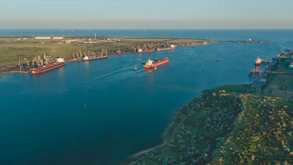 Ship departs from port, navigating through calm waters in the early morning light