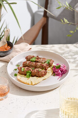 Kebabs with pita bread in bright natural light, overhead minimalist plating