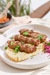 Kebabs on pita bread in bright natural lighting, overhead composition