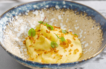 Mashed potatoes with crispy onions, bright lighting, artisan ceramic bowl, overhead composition