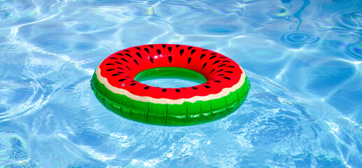Summer day by the pool. Floating beach ball on pool water. Summer background. Inflatable toy....