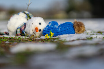 Snowman melting in warm winter or spring weather. Melted snowman as a symbol of climate change....
