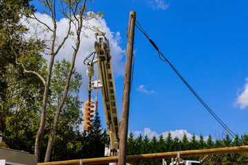 Crane is lifting poles into place as construction crews work on residential project during repair...