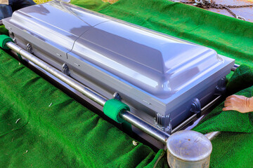 Coffin being handled during funeral preparation somber atmosphere reflects seriousness of occasion.