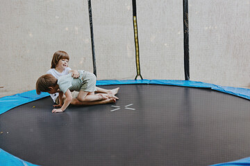 Happy children playing on a trampoline, enjoying their carefree moments in bright, playful...