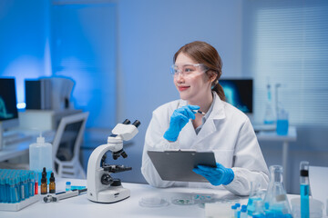 Female scientist wearing protective gear works in a laboratory, analyzing samples with a...