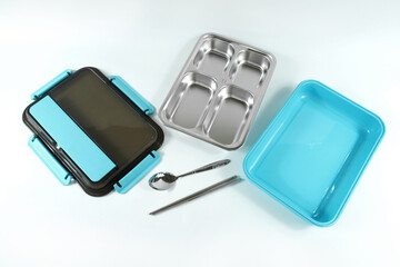 Plastic and stainless lunch box, which is black and blue in color. n white background, food...