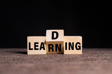 leading and learning words symbol on wooden blocks on dark black background
