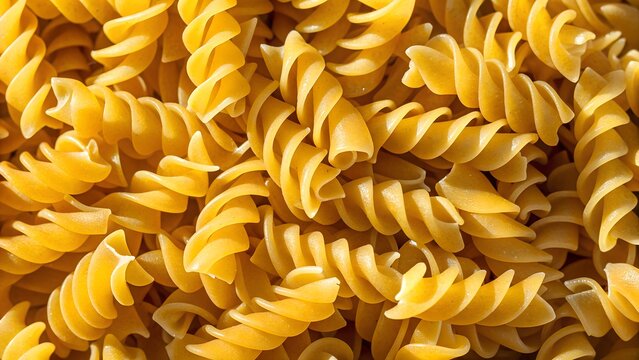A pile of uncooked fusilli pasta creates a textured background